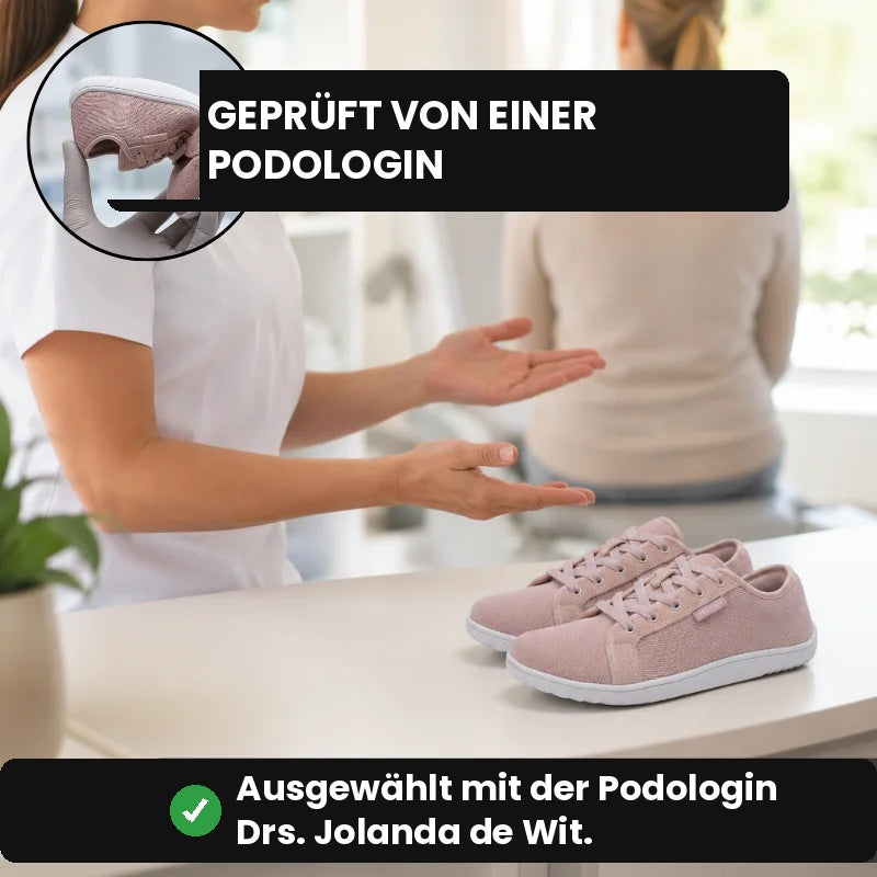 Rosa Ruimevo® Sneaker auf einem Tisch in einer Praxis, eine Fachkraft zeigt darauf, oben die gebogene Sohle im Detail