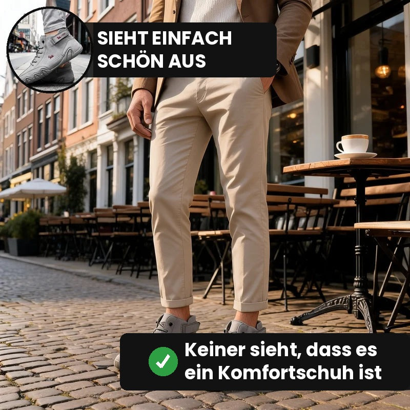Mann in Chinohose mit grauen Barevo Schuhen vor einem Straßencafé