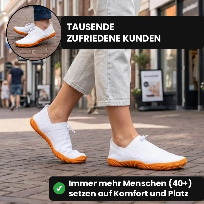 Person geht in weißen Glidevo Slippern durch eine Einkaufsstraße