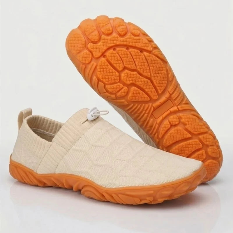 Glidevo Slipper in Beige mit oranger Sohle, Seitenansicht und Sohlenprofil