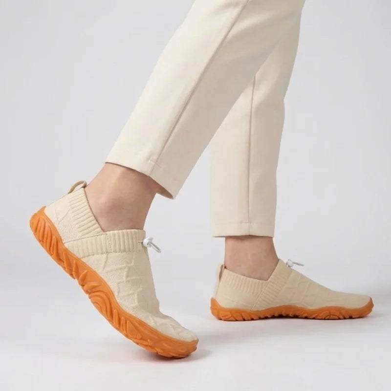 Person in heller Hose geht in beigen Glidevo Slippern
