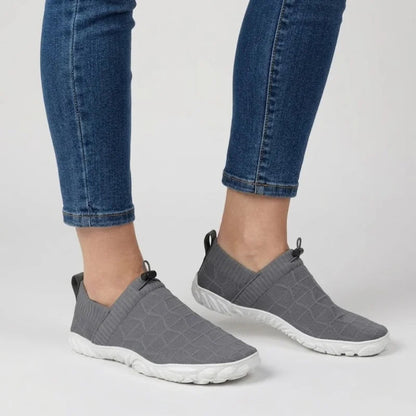 Person in Jeans trägt graue Glidevo Slipper