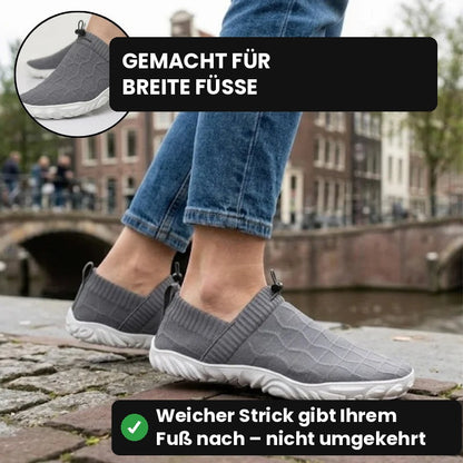 Graue Glidevo Slipper beim Spaziergang an einer Gracht