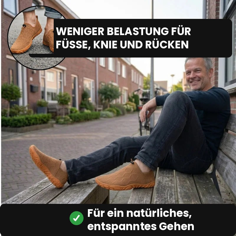 Lächelnder Mann sitzt auf einer Bank und trägt braune Glidevo Slipper