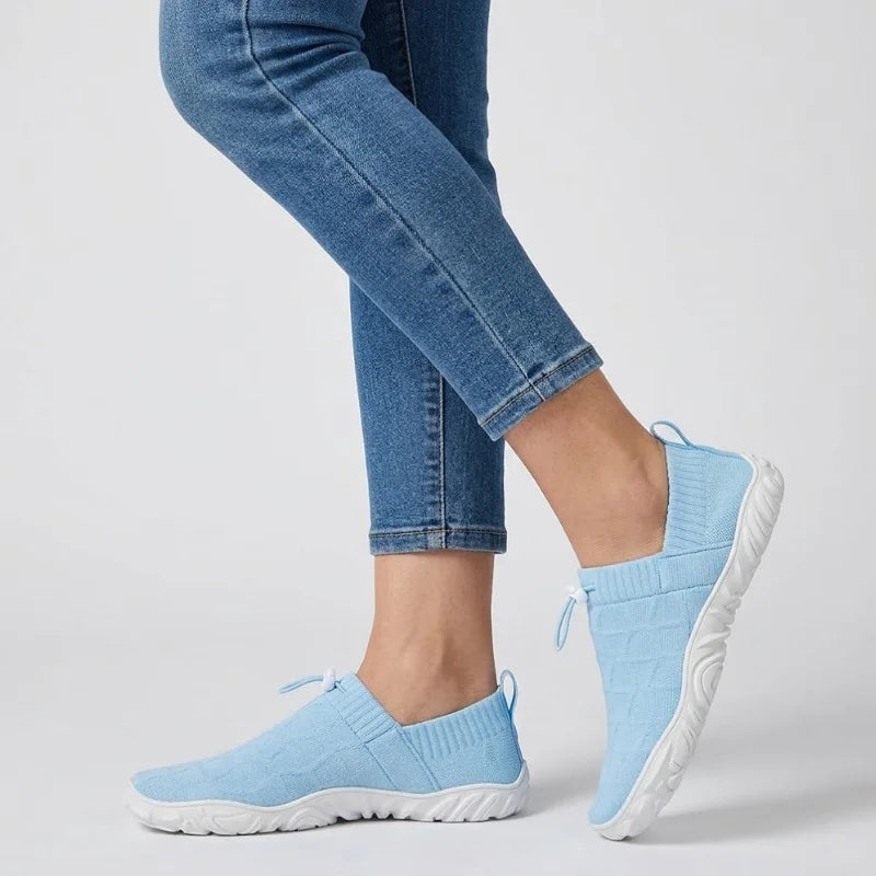 Person in Jeans geht in hellblauen Glidevo Slippern