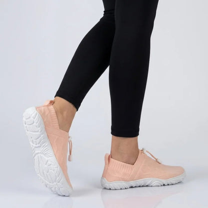 Person in schwarzen Leggings geht in rosa Glidevo Slippern