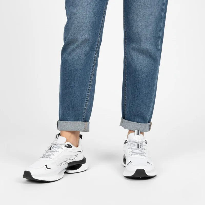 Weiße NordStep® Sneaker am Fuß, getragen zur Jeans