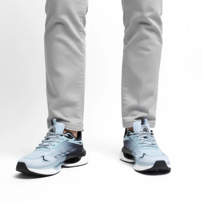 Blaue NordStep® Sneaker am Fuß, getragen zur hellgrauen Hose