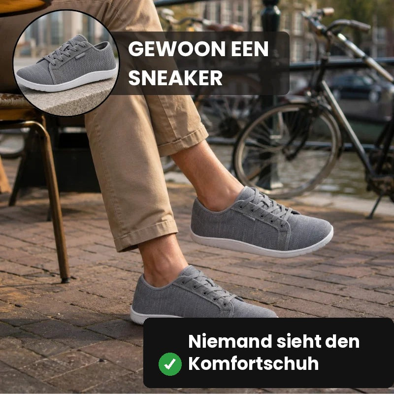 Graue Ruimevo® Sneaker im Sitzen vor einem Straßencafé, im Hintergrund Fahrräder