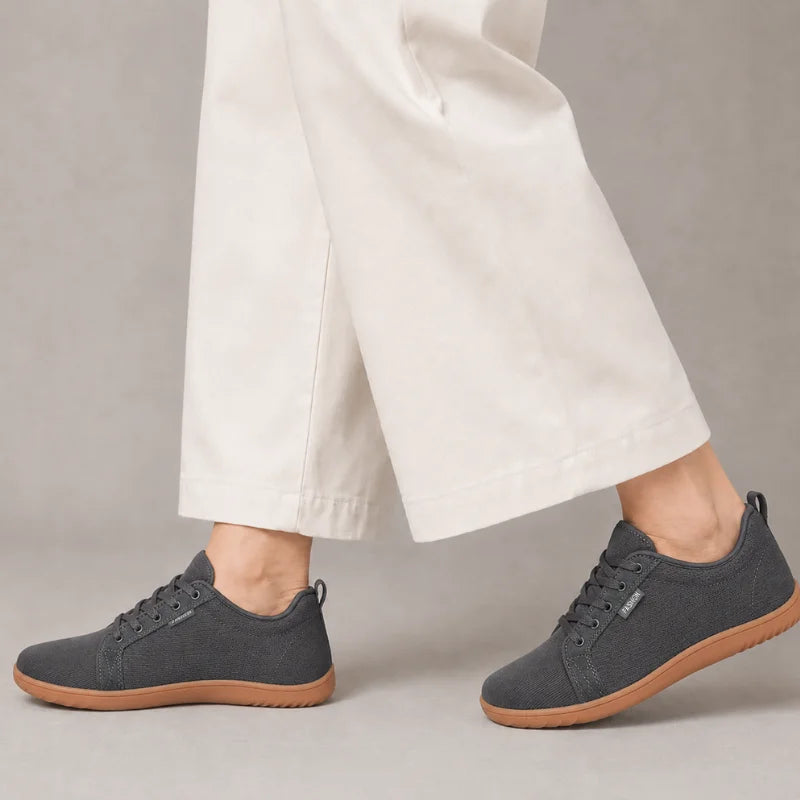 Dunkelgraue Ruimevo® Sneaker am Fuß, getragen zu einer hellen, weiten Hose