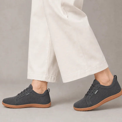 Dunkelgraue Ruimevo® Sneaker am Fuß, getragen zu einer hellen, weiten Hose
