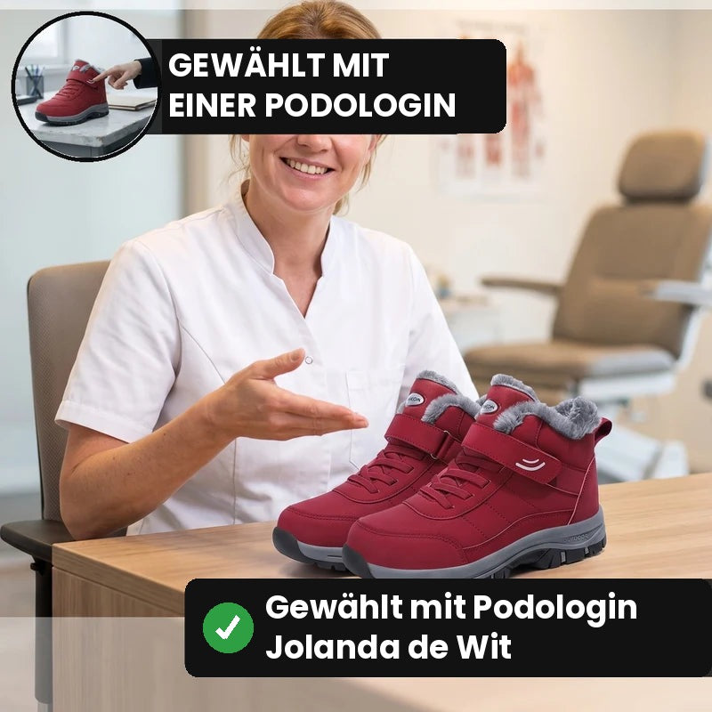 Podologin zeigt die Warmevo® Winterschuhe in Rot in der Praxis