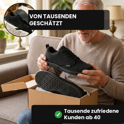Älterer Mann packt schwarze WideStep Sneaker auf dem Sofa aus